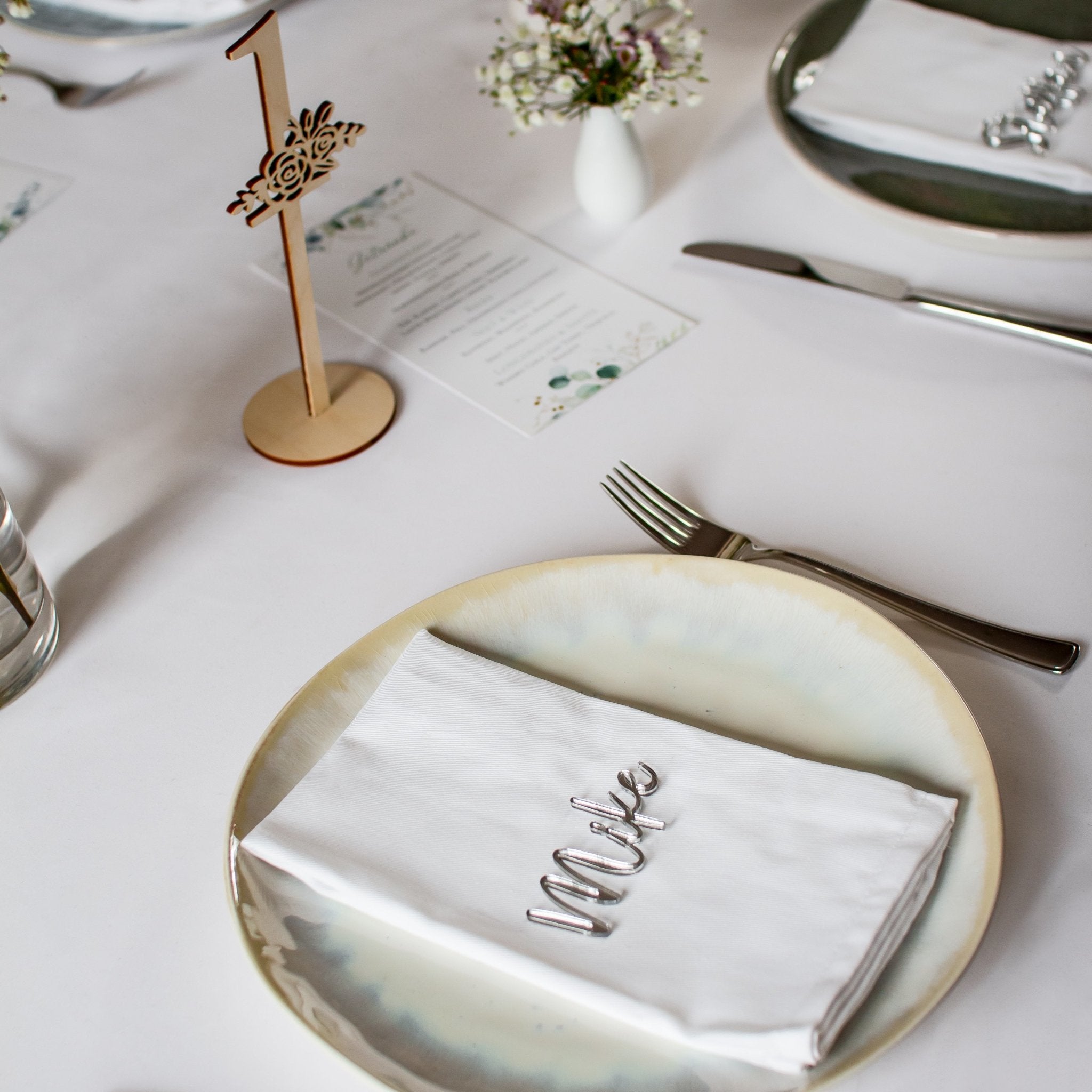 Platzkarte silber mit dem Namen . Schriftzug in Schreibschrift aus Spiegel-Acryl dient der Tischdekoration zur Hochzeit.